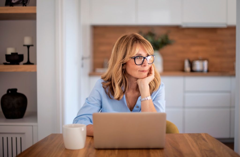 A person wearing glasses while working at their computer