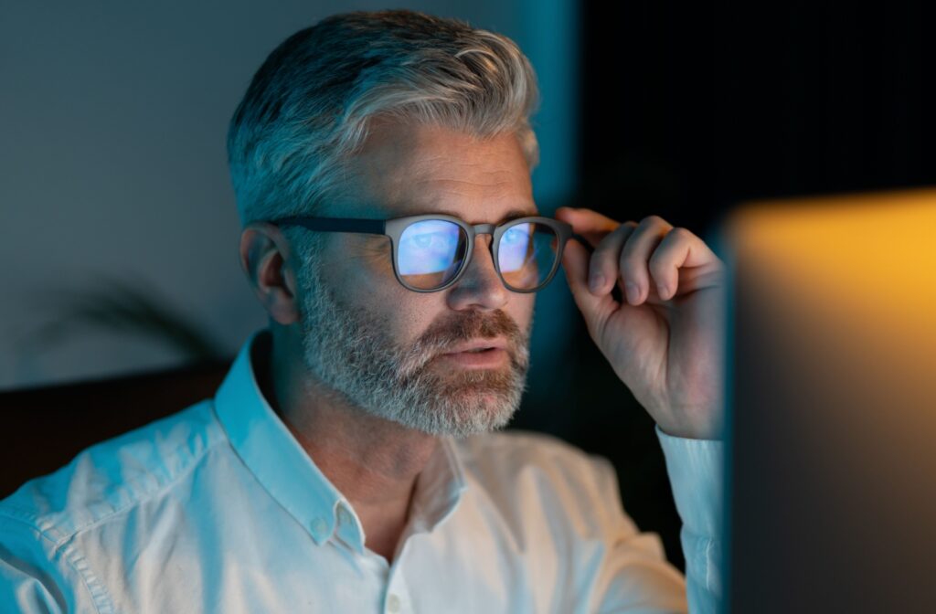 A person wearing blue light glasses for working at a computer screen.