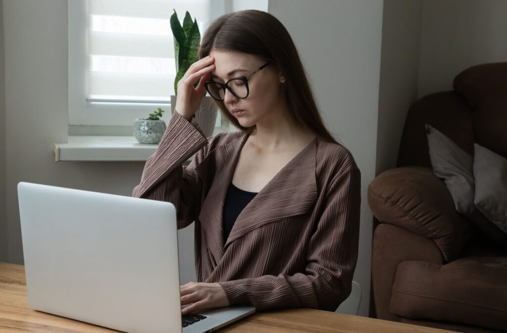 A person experiencing eye strain symptoms after starring at their laptop screen too long.
