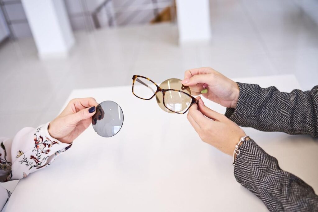 A person holding a pair of frames with different lenses options to help correct vision.